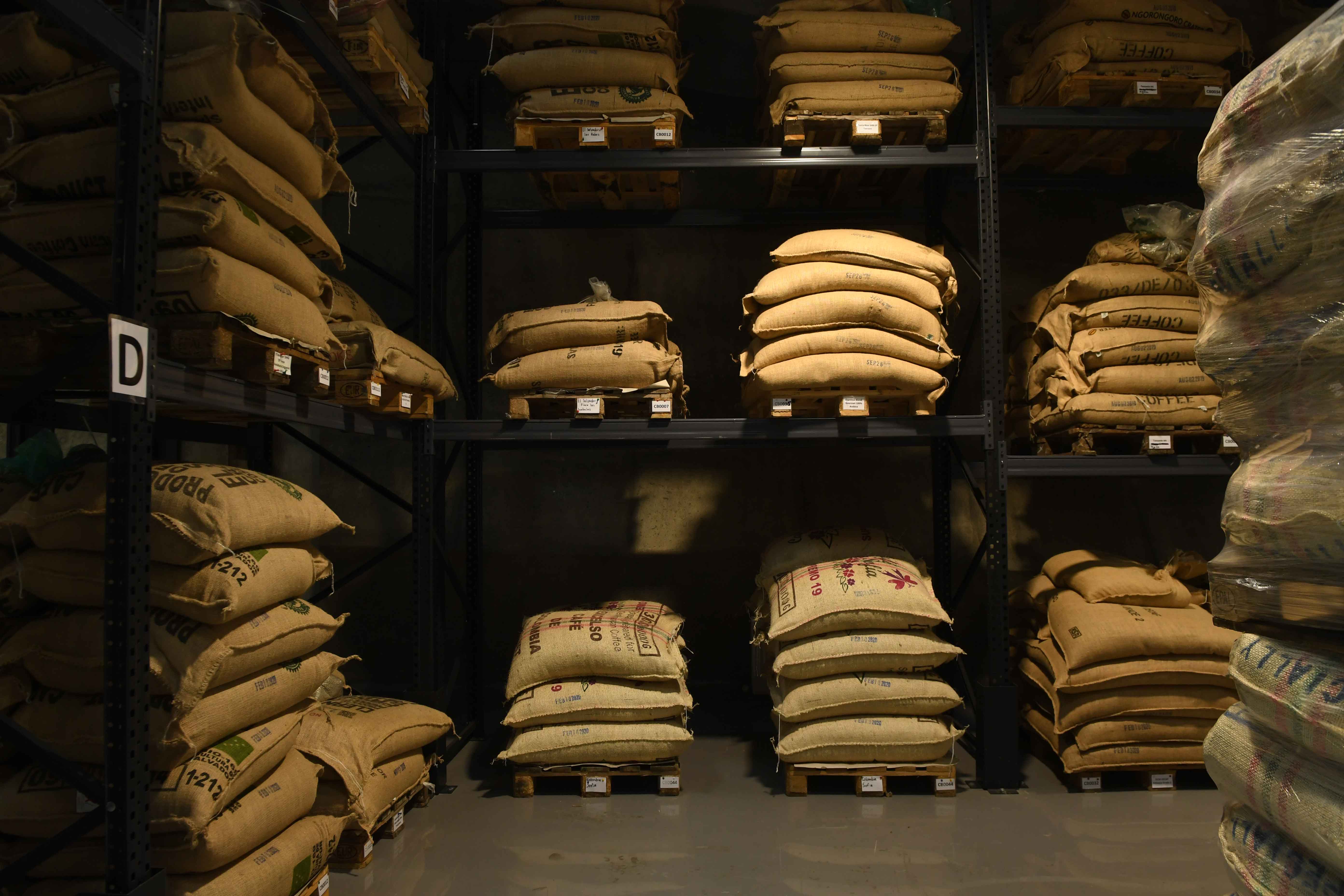 Lager mit Kaffeebohnen in Säcken auf Paletten in Regalen
