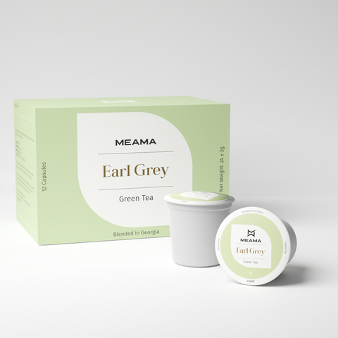 Zwei Multi-Tee-Kapseln der Sorte Earl Grey Grüntee stehen im Vordergrund, dahinter die passende Verpackung