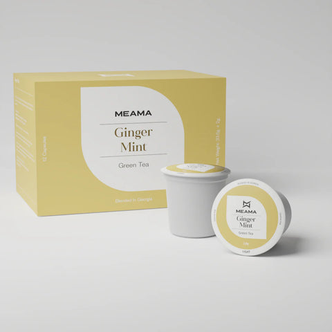 Zwei Multi-Tee-Kapseln der Sorte Ginger Mint stehen im Vordergrund, dahinter die passende Verpackung