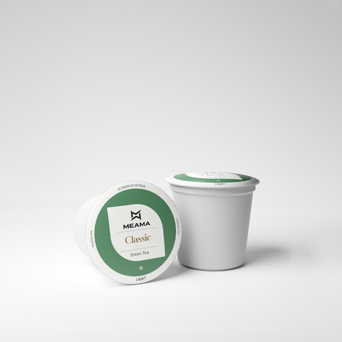 Zwei Multi-Tee-Kapseln der Sorte Classic Green Grüntee auf weißem Hintergrund