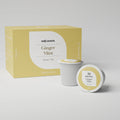 Zwei Multi-Tee-Kapseln der Sorte Ginger Mint stehen im Vordergrund, dahinter die passende Verpackung